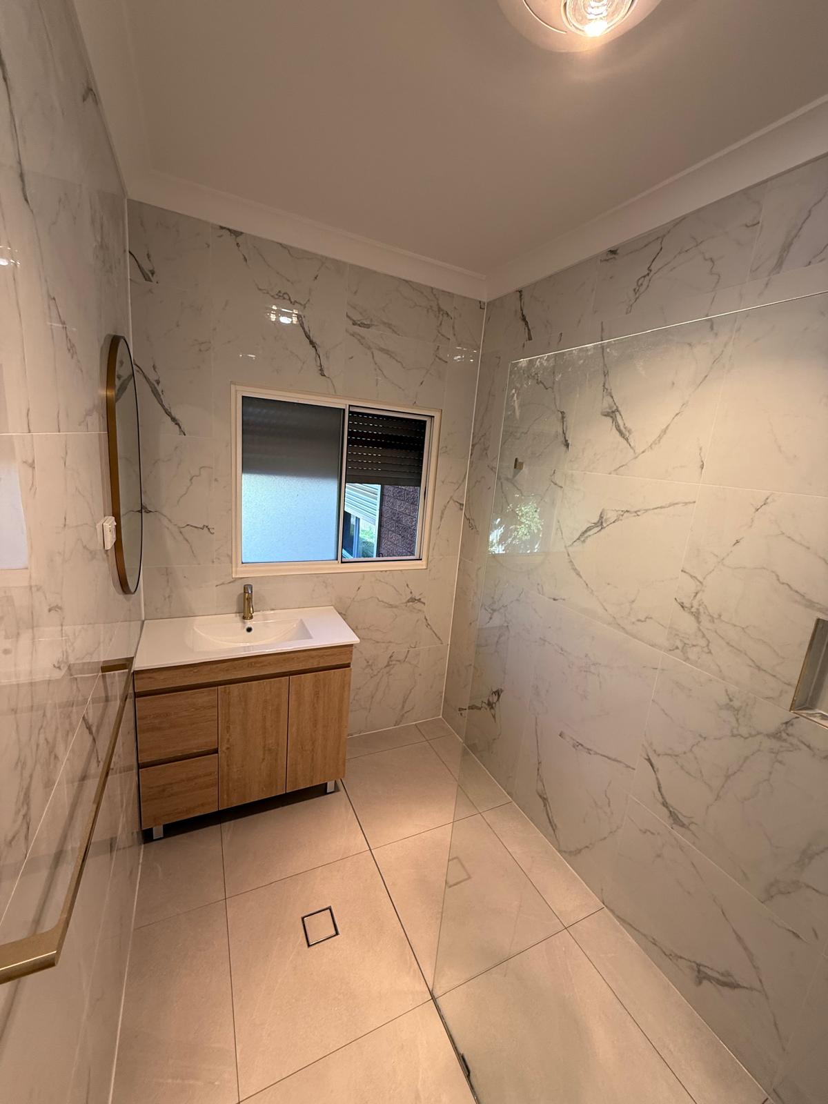 Shower recess — marble tiling with glass panel